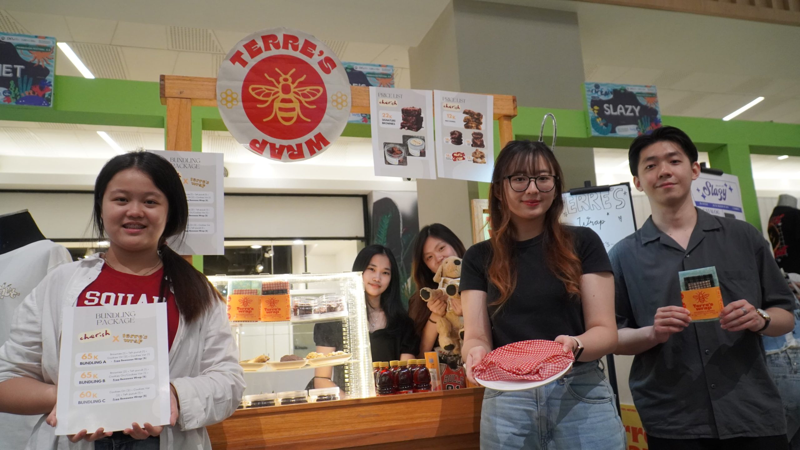Mahasiswa Business Management Petra Christian University Surabaya sedang berdiskusi dengan Founder Kepo Market di depan stan produk inovatif mereka.